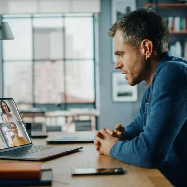 Handsome caucasian man having a video call on laptop computer wh